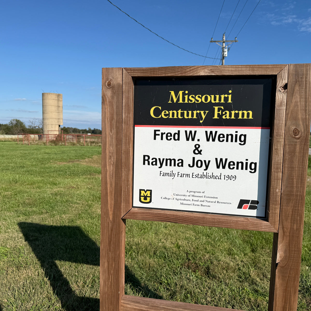 Wooden sign for Missouri Century Farm with a silo in the background